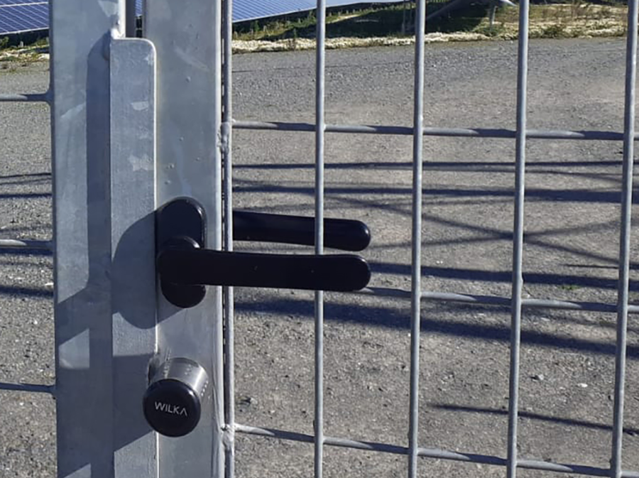 Szczegółowy widok elektronicznego cylindra zamka WILKA easy w metalowej bramie